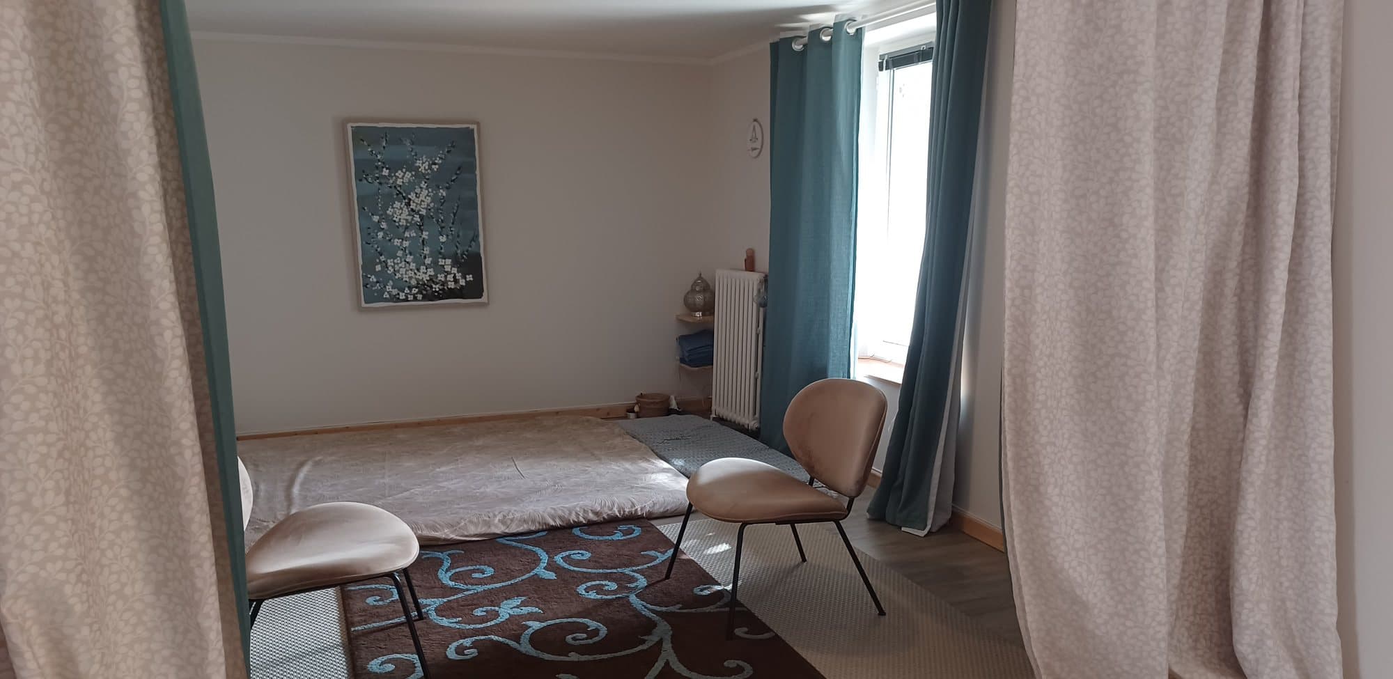 Salle de massage de Quiétude à Brest, futon au sol et tapis, ambiance calme et lumière douce.